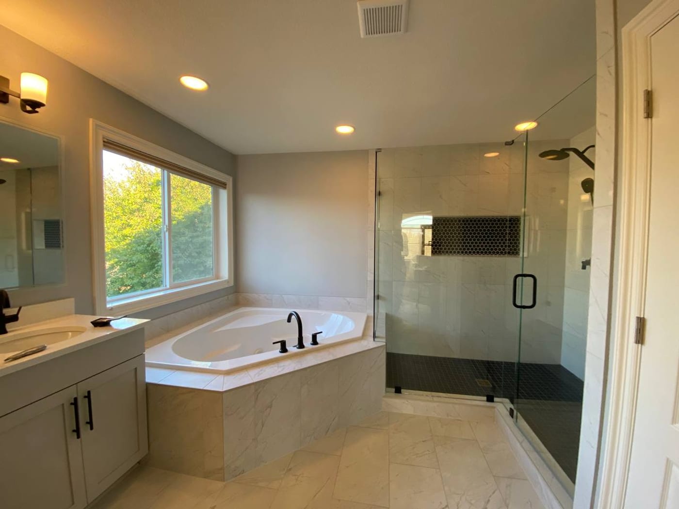 Drop-in tub and a glass walk-in shower by Artemidas Renovation, Loganville